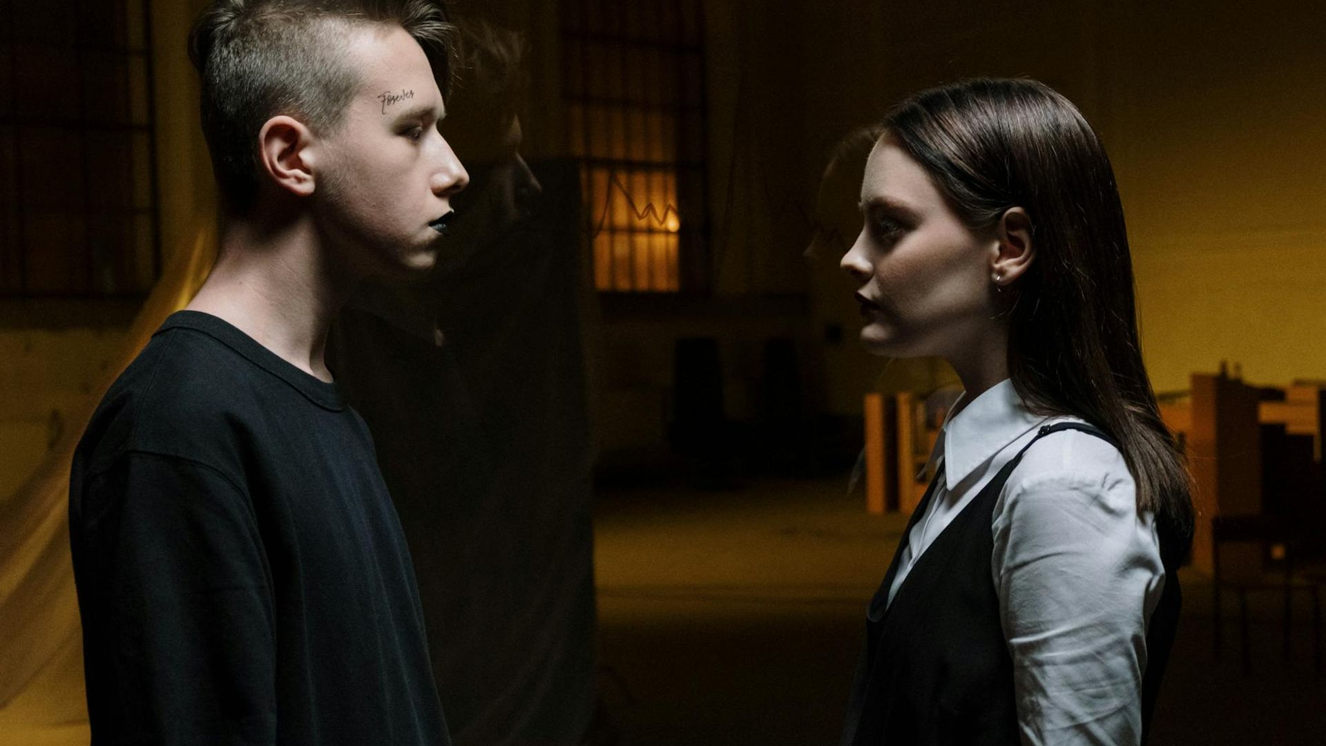Man in a focused, athletic pose in a dark, atmospheric setting.