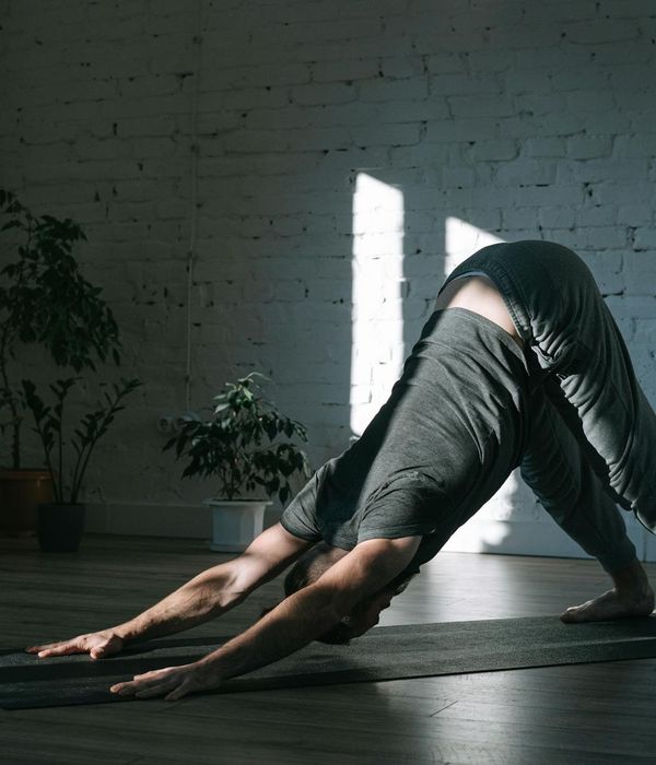 Man stretching on a mat in a calm, focused environment.